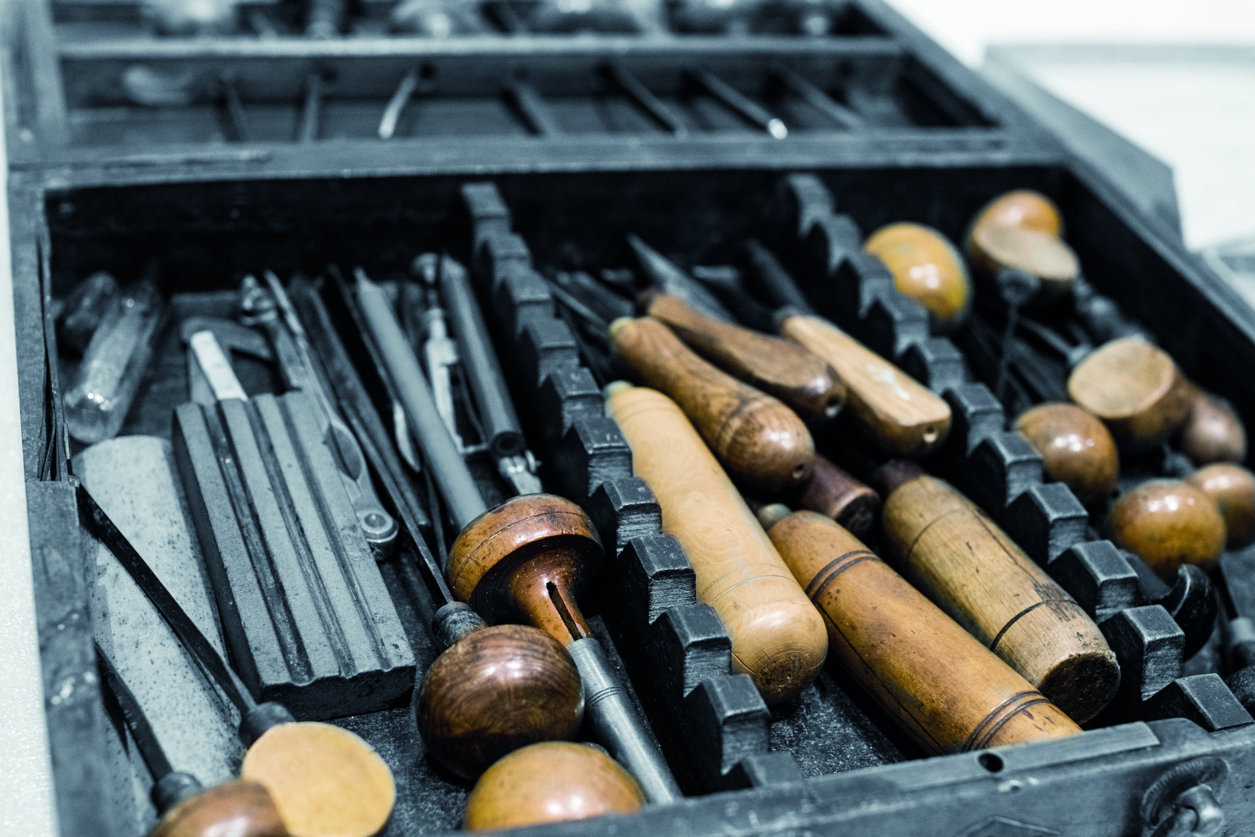 Antique tools for engraving and printing in a wooden case.
