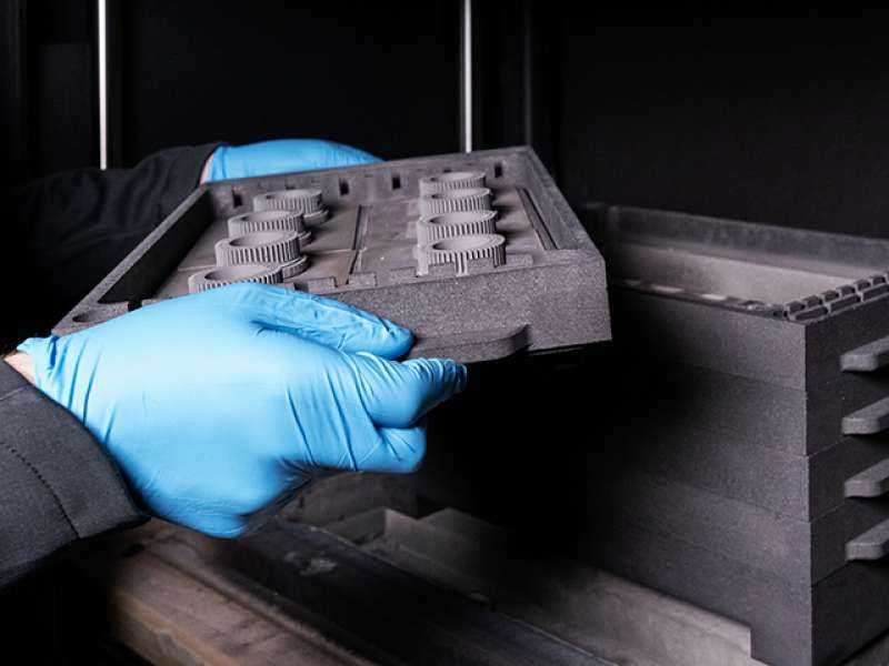 Desktop Metal Studio System 2 6 hands in gloves holding 3d print