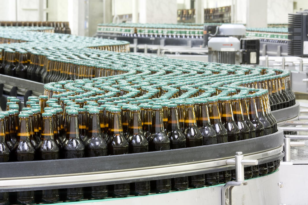 Bottles of beer on conveyor in brewery Controllo ottico del livello di riempimento nella produzione